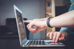 Two people looking at laptop screen reading why too much screen time is bad for health