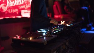 View from the front of the crowd looking upon the DJ decks of a night club