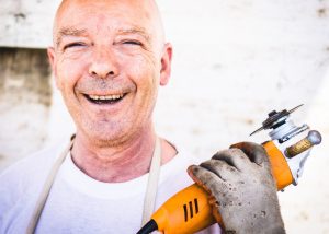 Close up of woodworm specialist holding tool and smiling